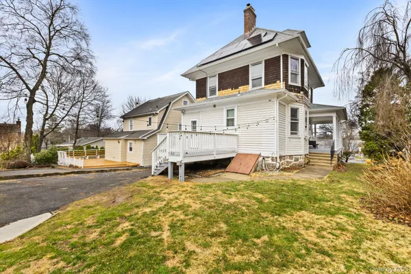 a view of a house with a large tree and a yard