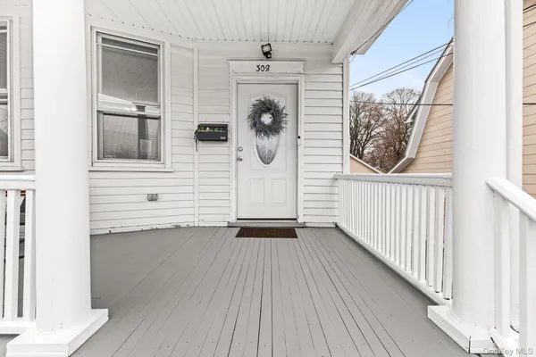 a view of a hallway with wooden floor and windows