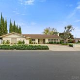 a front view of a house with a garden and plants