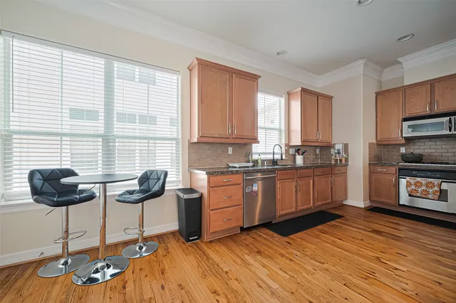 a kitchen with stainless steel appliances granite countertop a stove a sink and a refrigerator