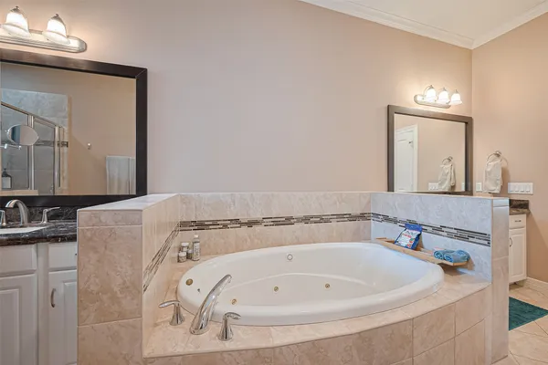 a bathroom with a tub sink and mirror