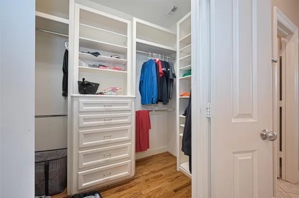 a view of walk in closet with clothes and shoes