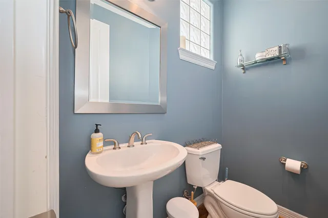 a bathroom with a sink a toilet and mirror