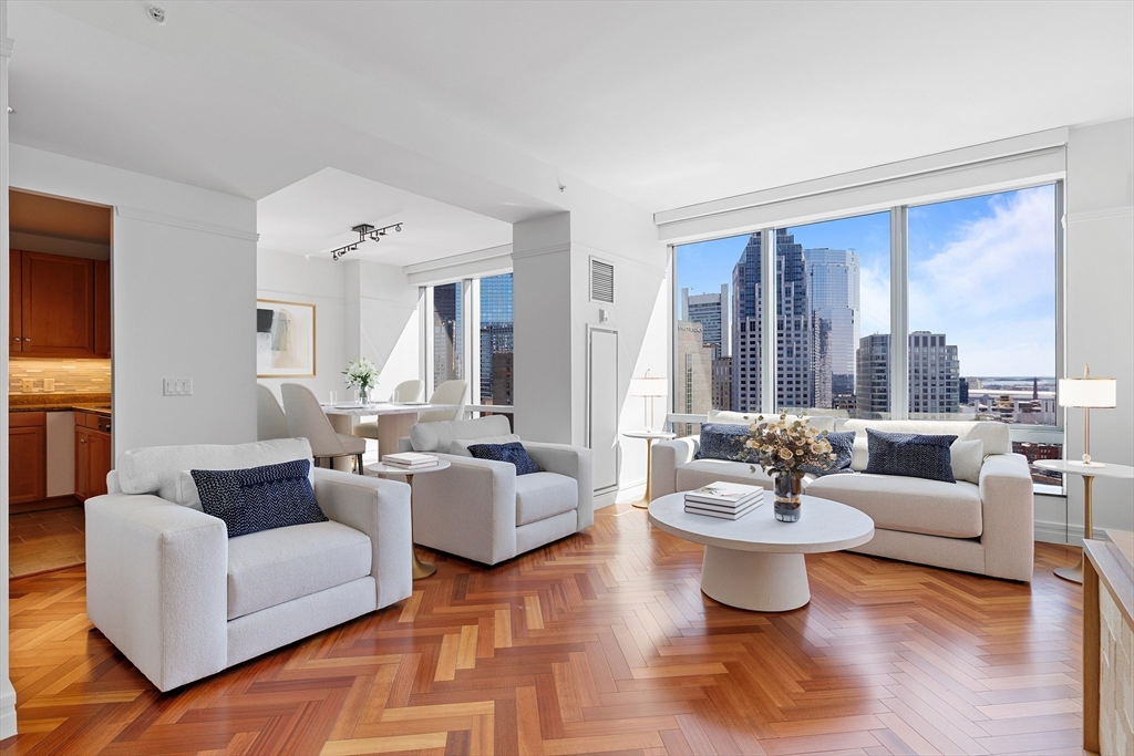 1 Avery Street, Unit 23C Boston, MA 02111 - Photo 1 of 22 a living room with fireplace furniture and floor to ceiling windows