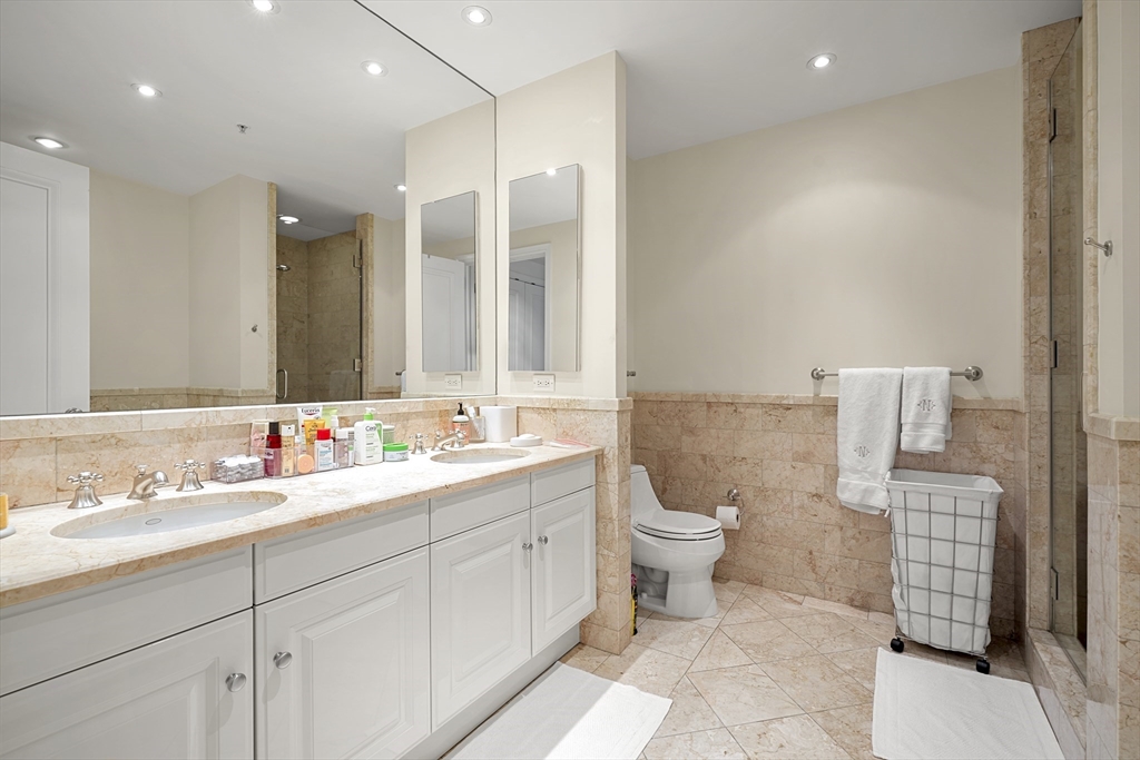 1 Avery Street, Unit 23C Boston, MA 02111 - Photo 13 of 22 a bathroom with a double vanity sink mirror and toilet