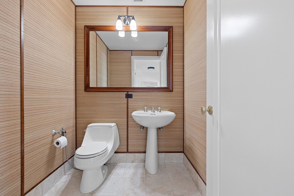 1 Avery Street, Unit 23C Boston, MA 02111 - Photo 8 of 22 a bathroom with a toilet sink and mirror