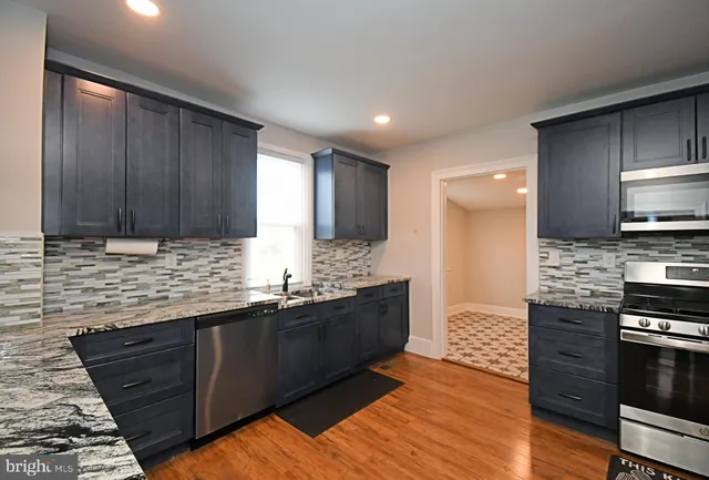 a kitchen with stainless steel appliances granite countertop a stove a sink and a refrigerator