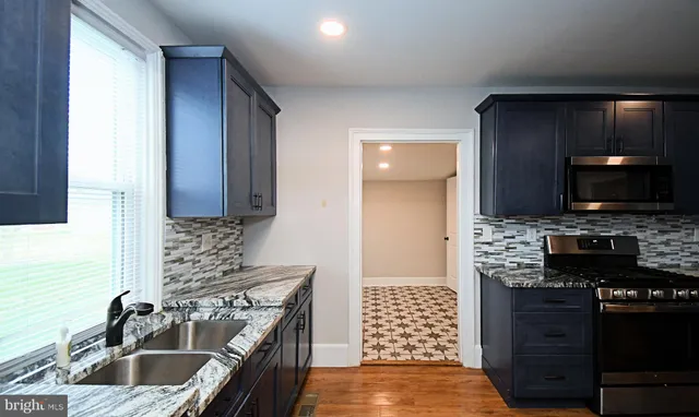 a kitchen with stainless steel appliances granite countertop wooden cabinets a refrigerator and a stove