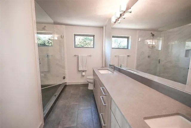 a spacious bathroom with a granite countertop sink a large mirror a shower and a bathtub