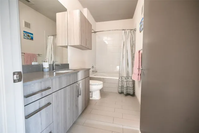 a bathroom with a granite countertop sink a toilet and a mirror