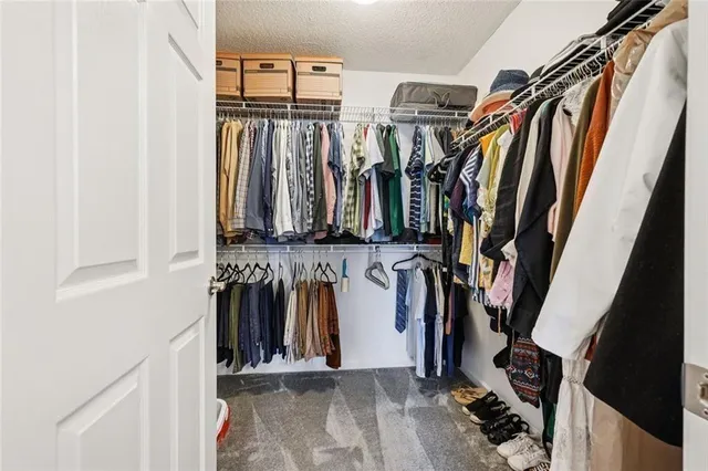 a view of walk in closet with clothes
