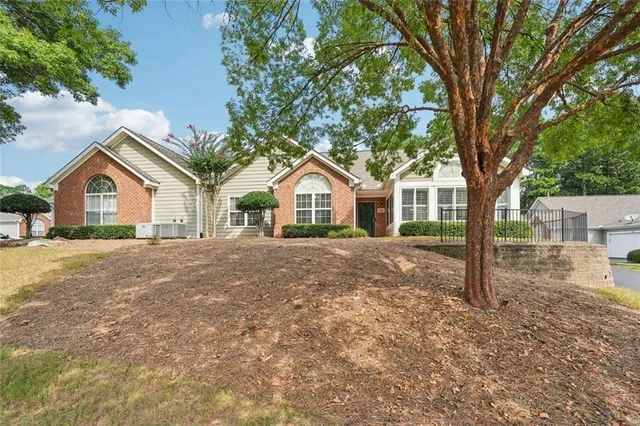 a view of house with yard and tree in front of it