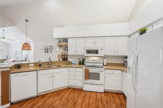 a kitchen with stainless steel appliances a white cabinets and wooden floor