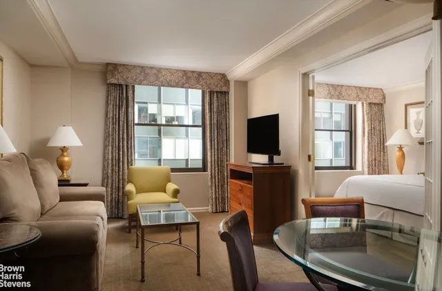 a living room with furniture a flat screen tv and a large window