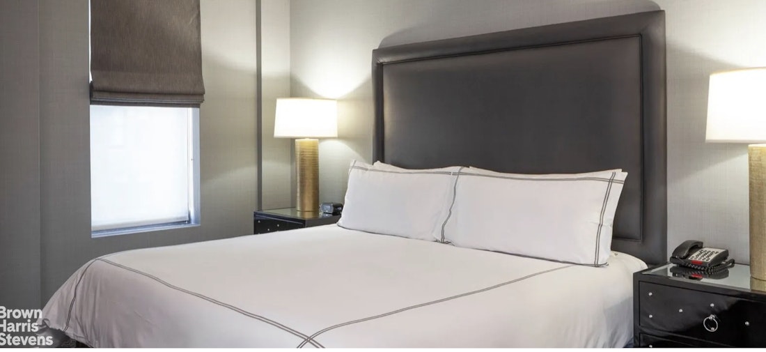 200 West 56th Street, Unit 1705 Manhattan, NY 10019 - Photo 4 of 12 a bed room with a bed and a tv