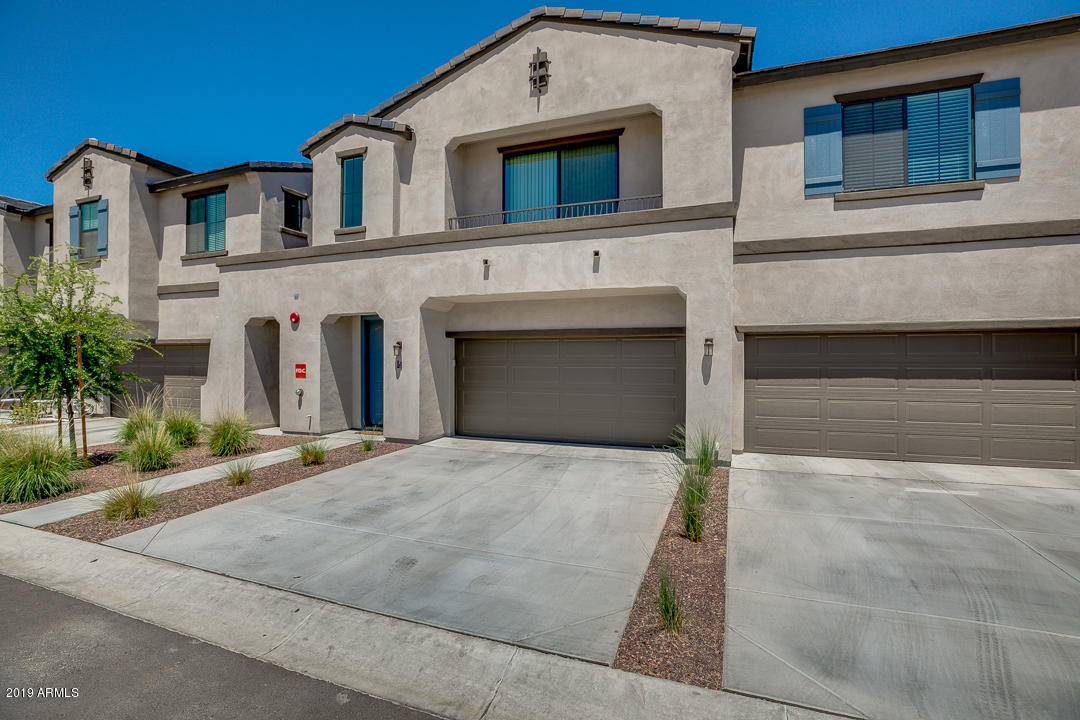 3900 East Baseline Road, Unit 114 Phoenix, AZ 85042 - Photo 2 of 31 a front view of a house with a yard and garage