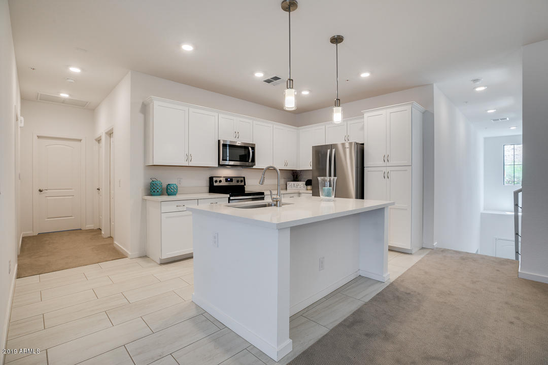 3900 East Baseline Road, Unit 114 Phoenix, AZ 85042 - Photo 7 of 31 a kitchen with kitchen island a sink stainless steel appliances and white cabinets
