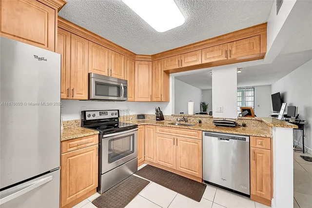 a kitchen with cabinets stainless steel appliances a sink and a window
