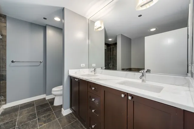 a bathroom with a double vanity sink toilet and a mirror