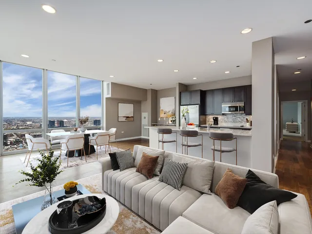 a living room with furniture kitchen and a large window