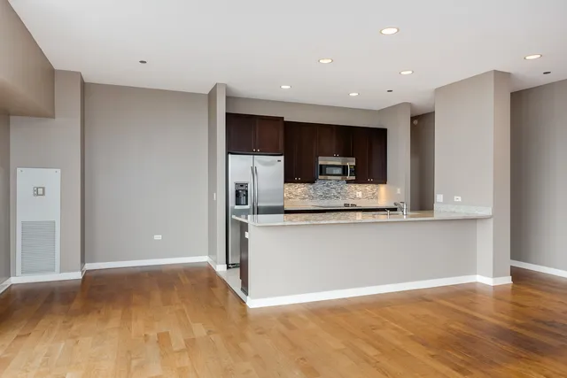 a view of kitchen with stainless steel appliances granite countertop a refrigerator and a sink