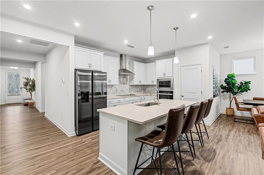 33 Brookside Way Cartersville, GA 30121 - Photo 17 of 54 a kitchen with stainless steel appliances a dining table chairs stove refrigerator and cabinets