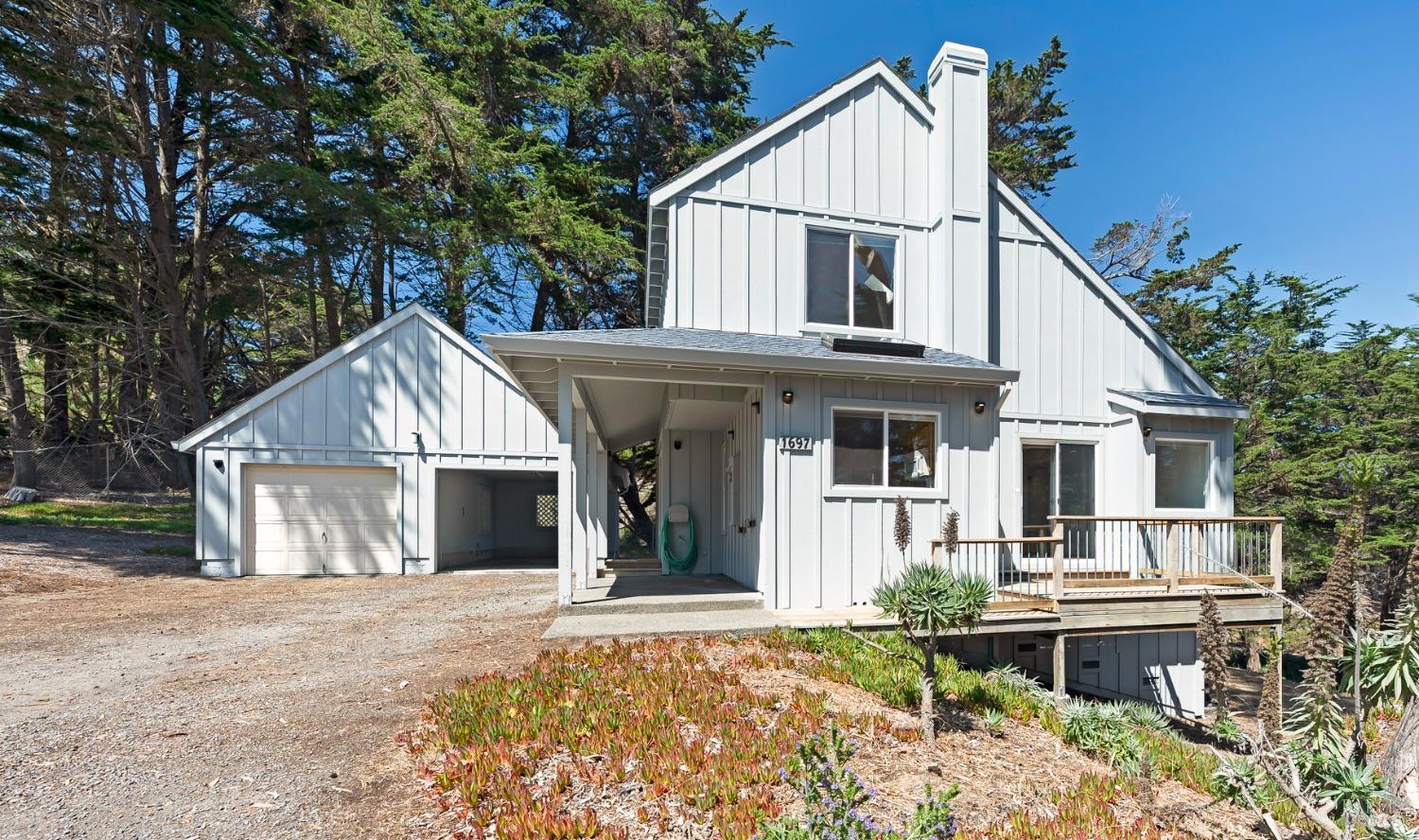 a view of house with yard outdoor seating and covered with trees