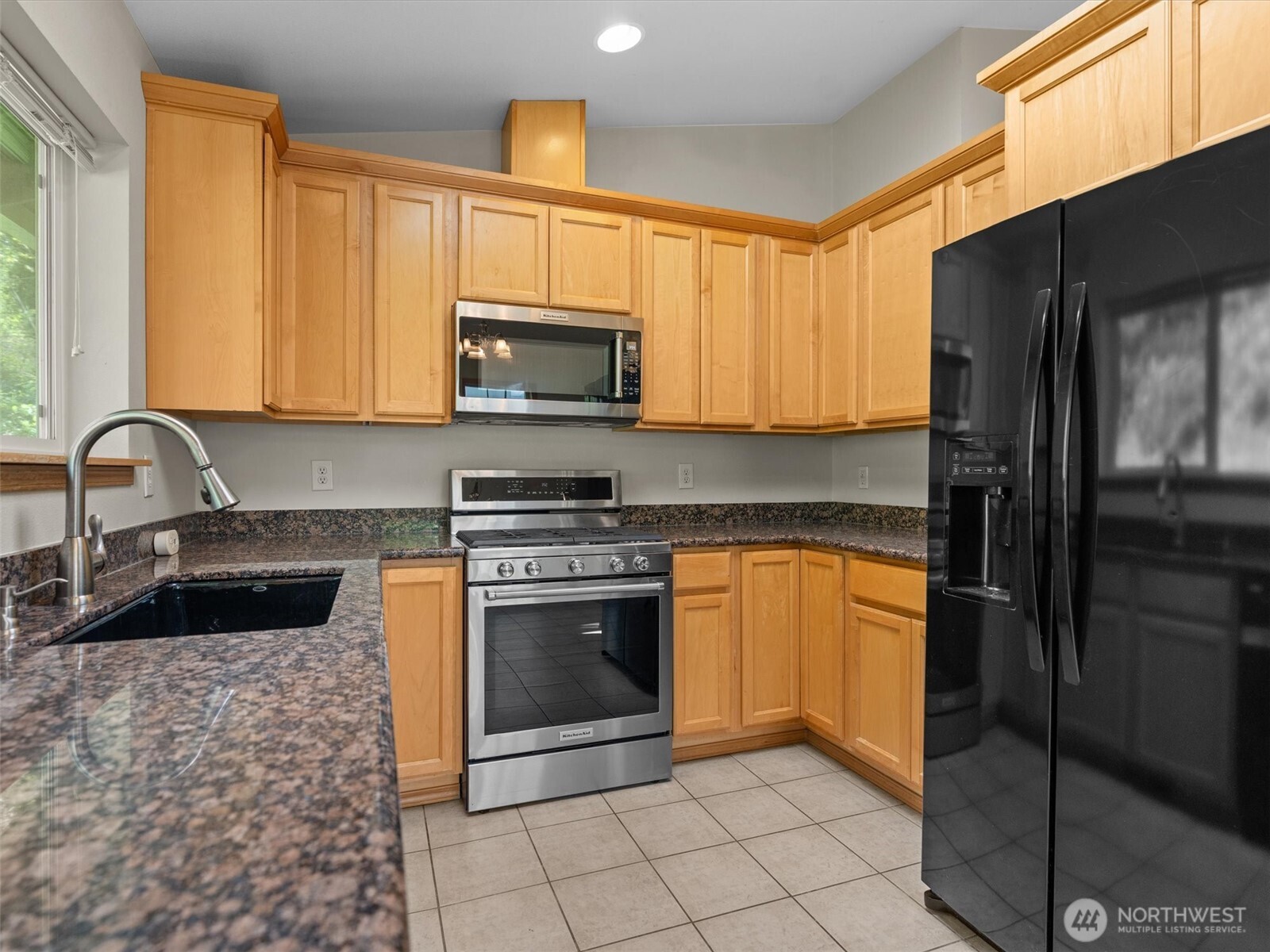5062 23rd Avenue Southwest Seattle, WA 98106 - Photo 12 of 39 a kitchen with stainless steel appliances granite countertop a stove a sink and a microwave