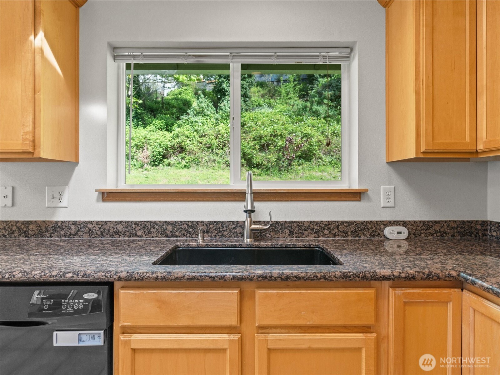 5062 23rd Avenue Southwest Seattle, WA 98106 - Photo 13 of 39 a kitchen with granite countertop a sink and a white wooden cabinets