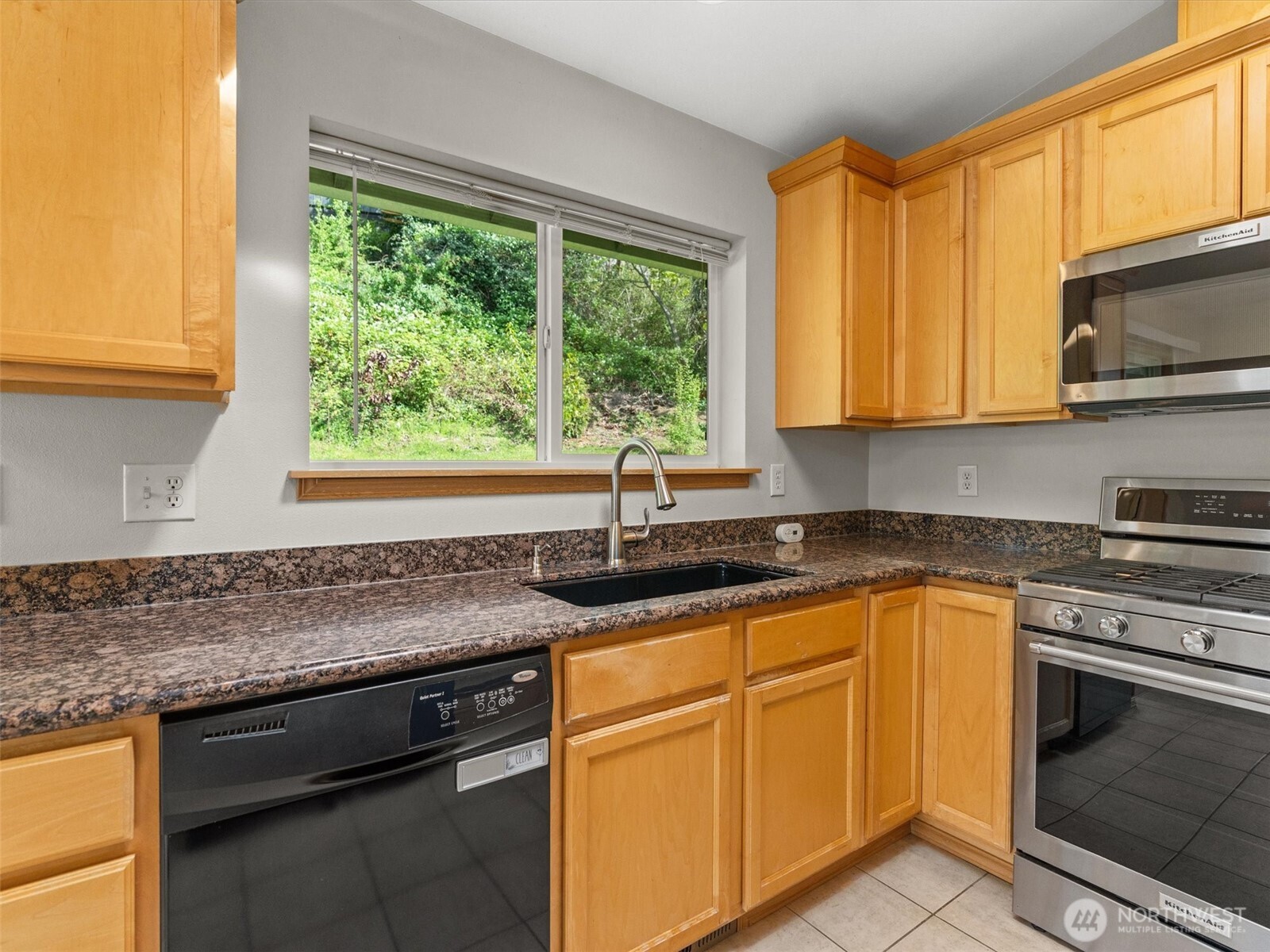 5062 23rd Avenue Southwest Seattle, WA 98106 - Photo 14 of 39 a kitchen with granite countertop stainless steel appliances a stove sink and microwave