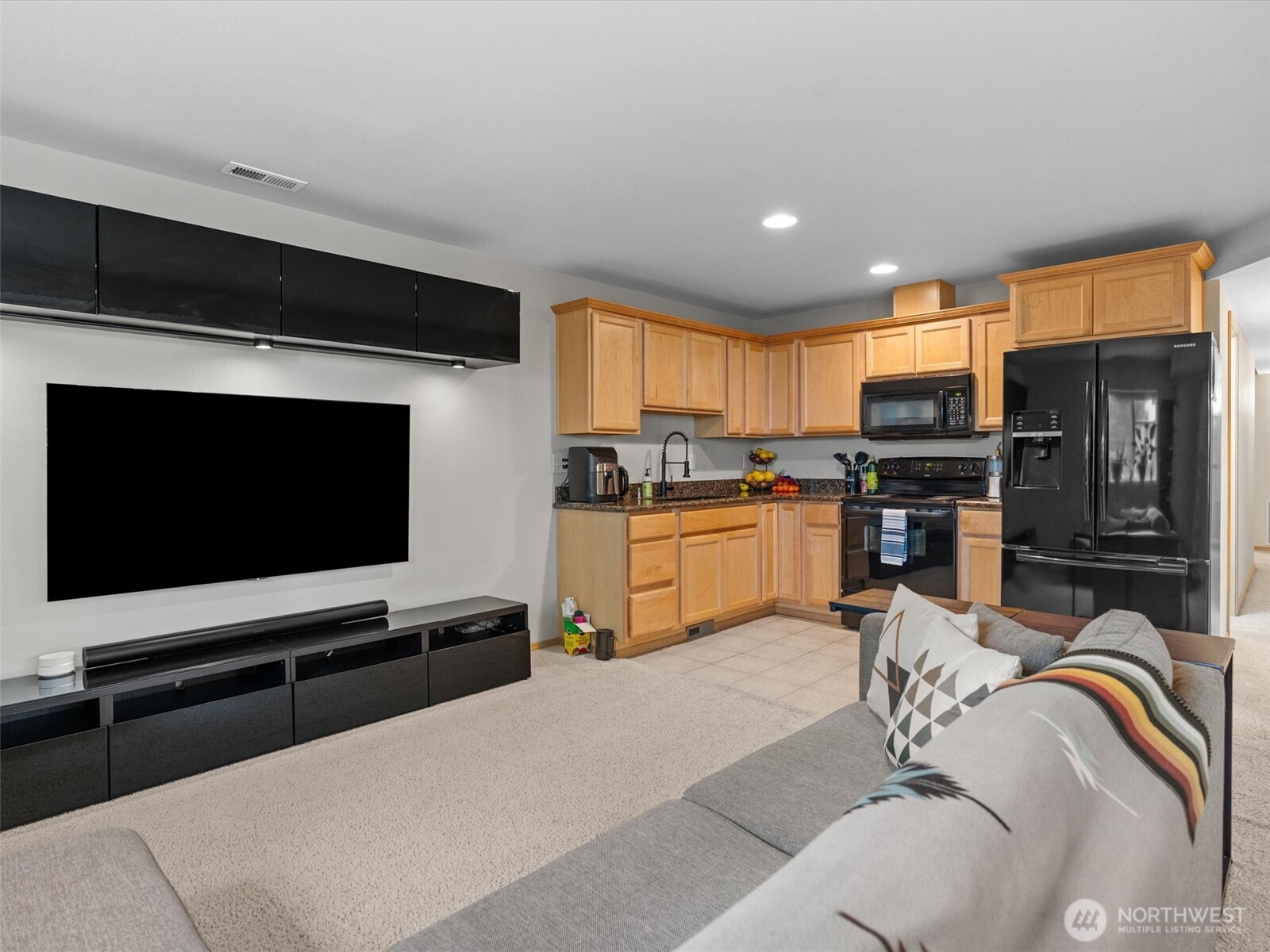 5062 23rd Avenue Southwest Seattle, WA 98106 - Photo 30 of 39 a living room with stainless steel appliances furniture a flat screen tv and a kitchen view