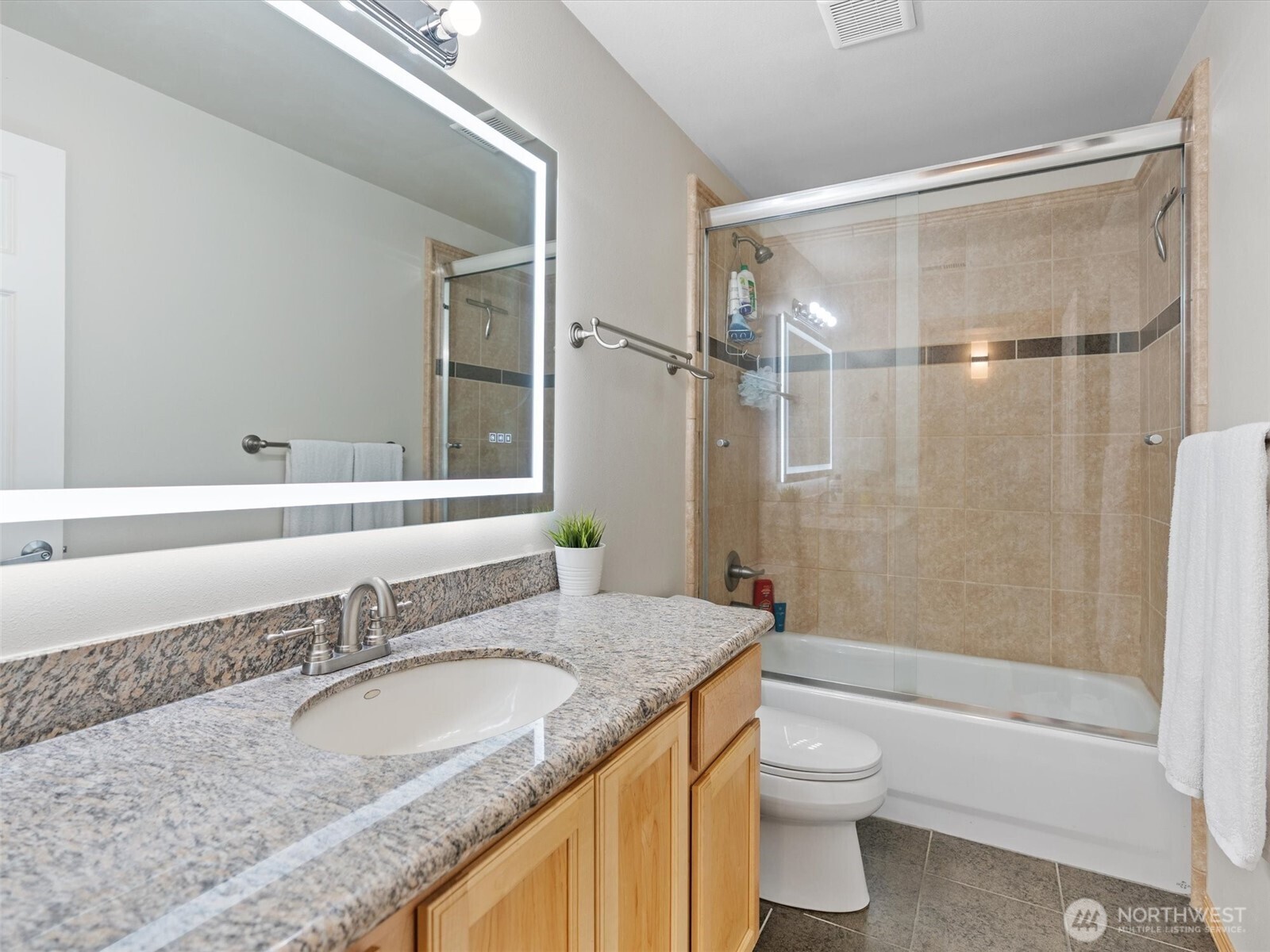 5062 23rd Avenue Southwest Seattle, WA 98106 - Photo 34 of 39 a bathroom with a granite countertop sink toilet and shower