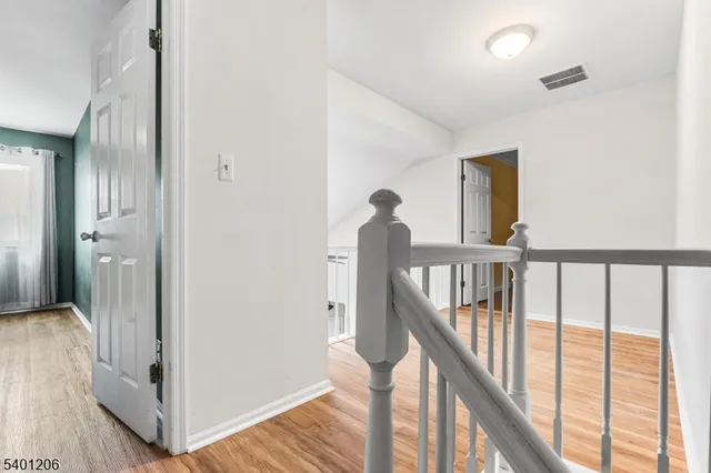 a view of a hallway with wooden floor and stairs