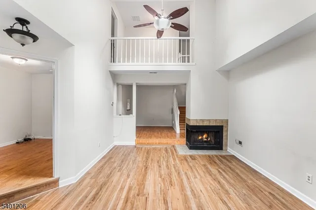 a view of a livingroom with wooden floor and a fireplace