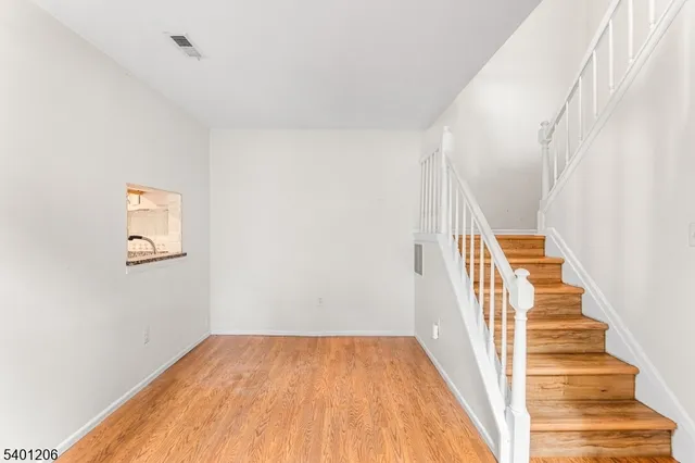 a view of a hallway with wooden floor and entryway