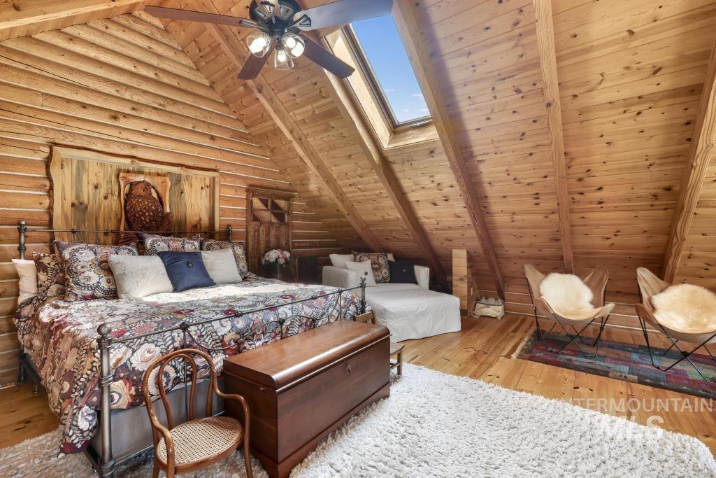 65 Goat Creek Way Stanley, ID 83278 - Photo 18 of 32 Attic room featuring extensive wood paneling, sloped ceilings, and wood-finish flooring