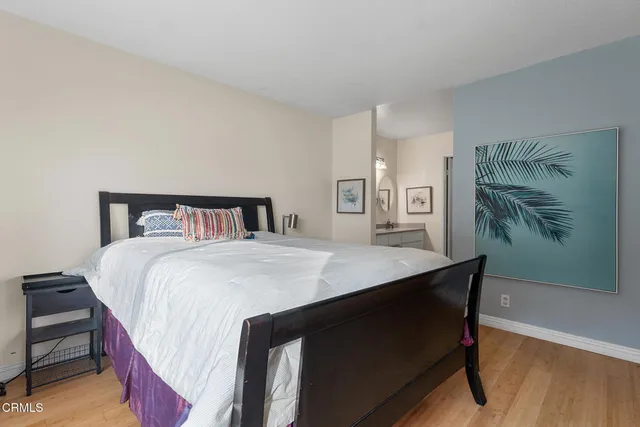 a bedroom with a bed and a painting on the wall