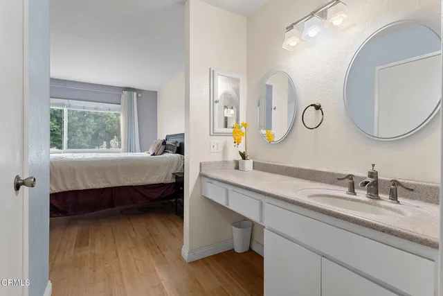 a en suite bathroom with a double vanity sink and a mirror