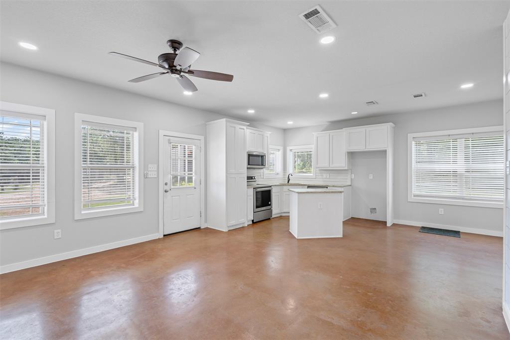 166 South Bronco Court Springtown, TX 76082 - Photo 11 of 40 a view of an empty room with wooden floor and a window