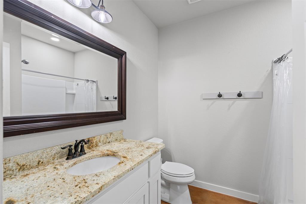 166 South Bronco Court Springtown, TX 76082 - Photo 14 of 40 a bathroom with a granite countertop sink vanity mirror and toilet