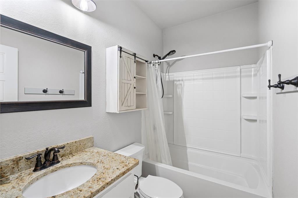 166 South Bronco Court Springtown, TX 76082 - Photo 19 of 40 a bathroom with a granite countertop sink toilet and shower
