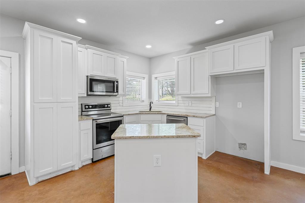 166 South Bronco Court Springtown, TX 76082 - Photo 10 of 40 a kitchen with granite countertop white cabinets and stainless steel appliances
