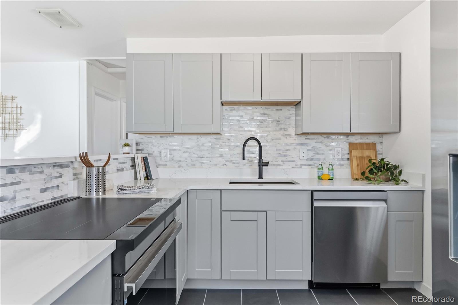 a kitchen with cabinets appliances a sink and a counter top space