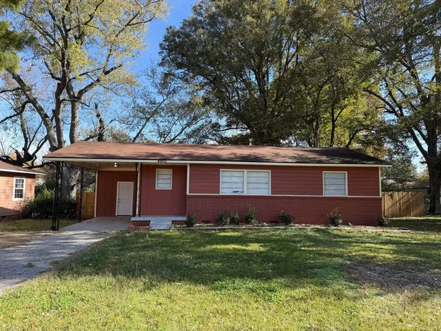 a front view of a house with a garden and yard
