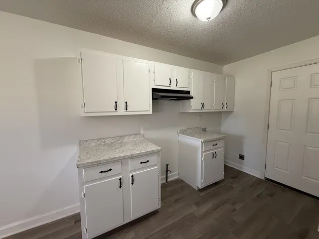 a kitchen with granite countertop a sink stove and refrigerator