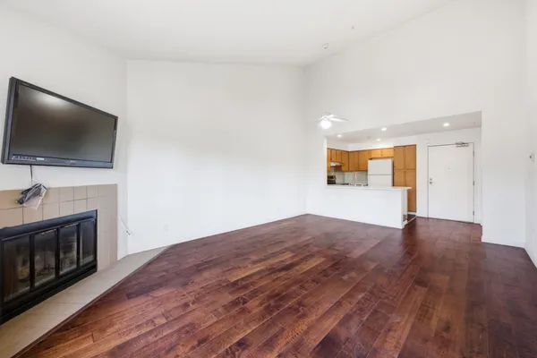 a view of a livingroom with a fireplace a flat screen tv and staircase