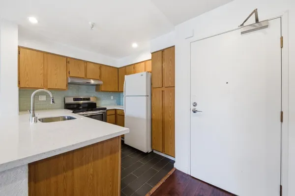 a kitchen with stainless steel appliances granite countertop a sink stove and refrigerator
