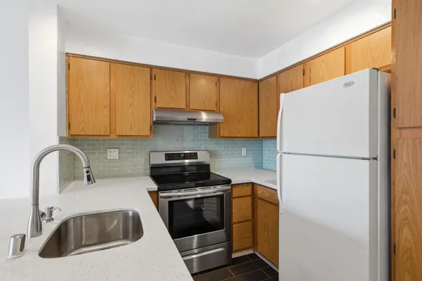 a kitchen with sink a stove and cabinets