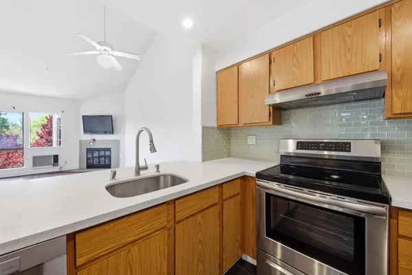 a view of kitchen view wooden floor wooden cabinets and stainless steel appliances