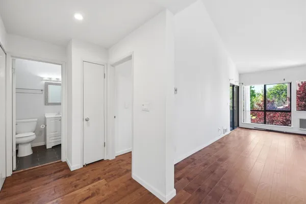 a view of bathroom with toilet window and wooden floor